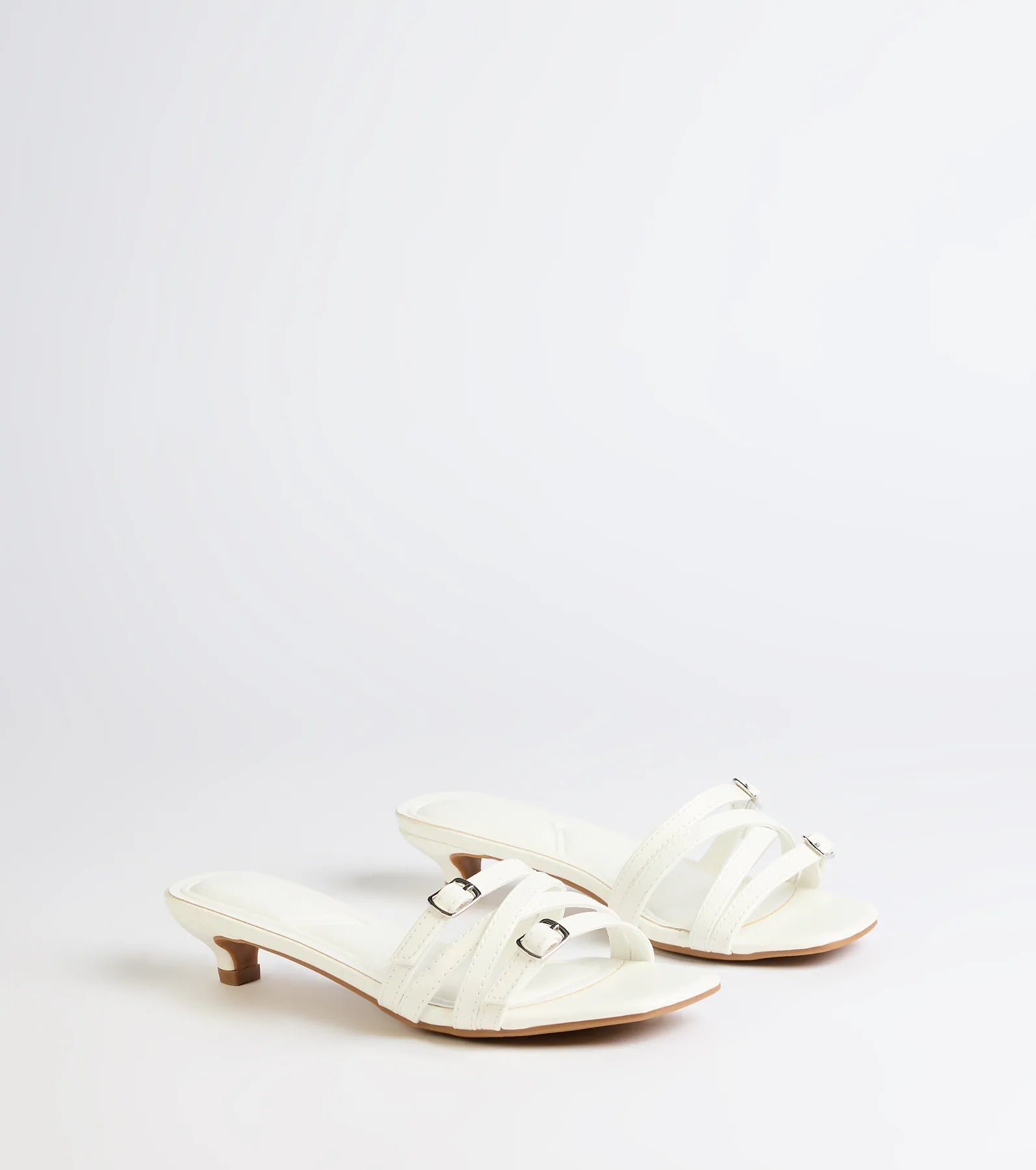 Style made simple with the Trendy Steps Buckle Strap Kitten Heel Mules in white, trendy women’s shoes that take your outfit from basic to bold in one step.