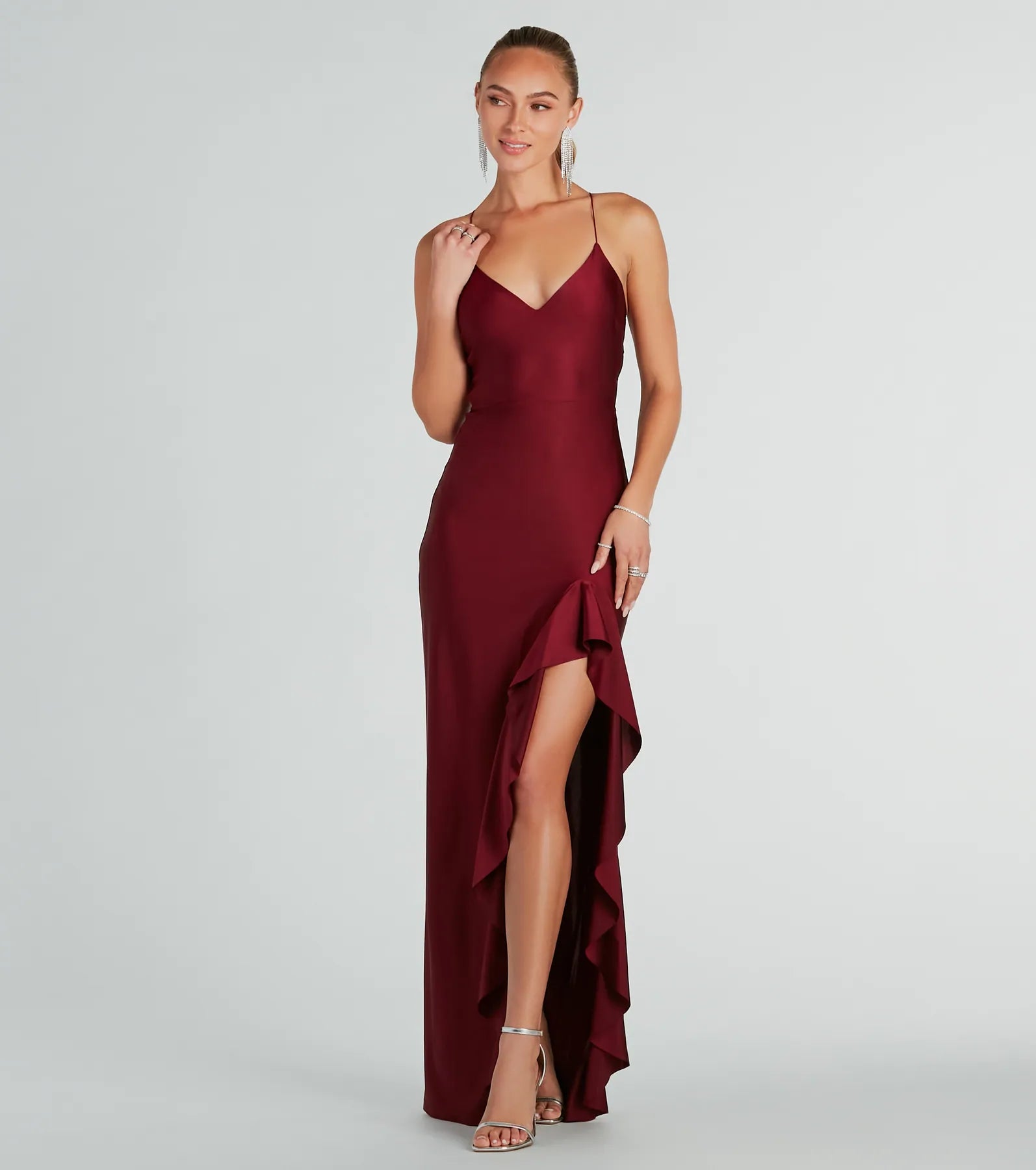 Turn heads at Prom 2025 in this burgundy prom dress, where statement-making details meet the iconic style of the Lainey Ruffled High Slit Long Formal Dress .