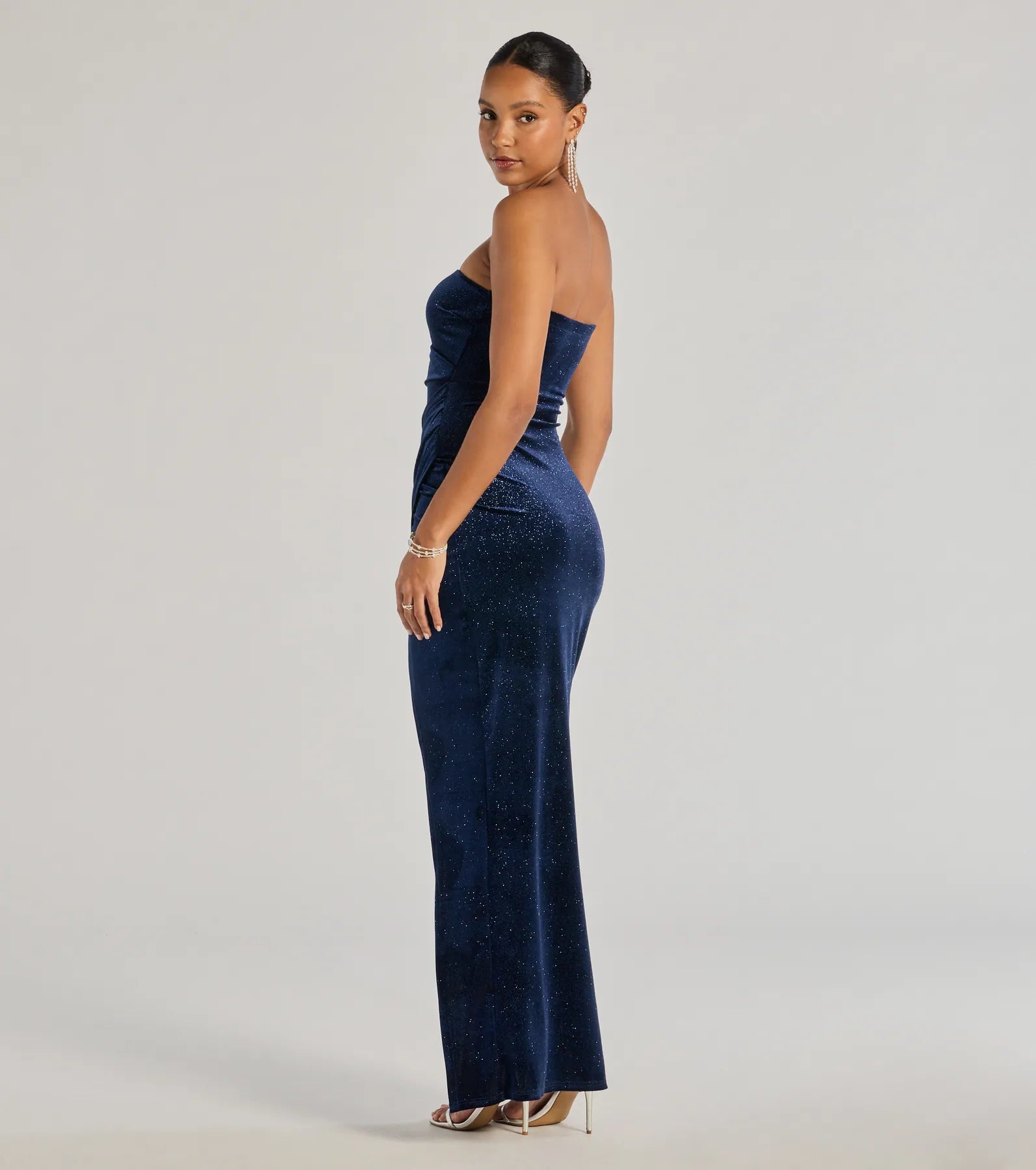 Step into the Prom 2025 dance in the Cordelia Velvet Glitter Long Wrap Dress in navy, a stunning blue prom dress designed to complement any theme with its timeless allure and statement-making style.