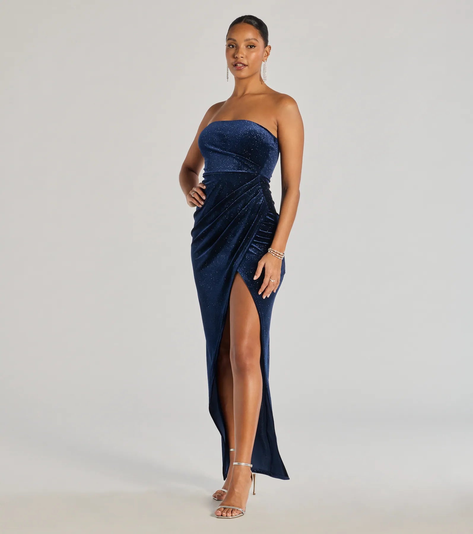 Step into Prom 2025 in a navy blue prom dress, where unique Windsor accents and the standout Cordelia Velvet Glitter Long Wrap Dress style come together.