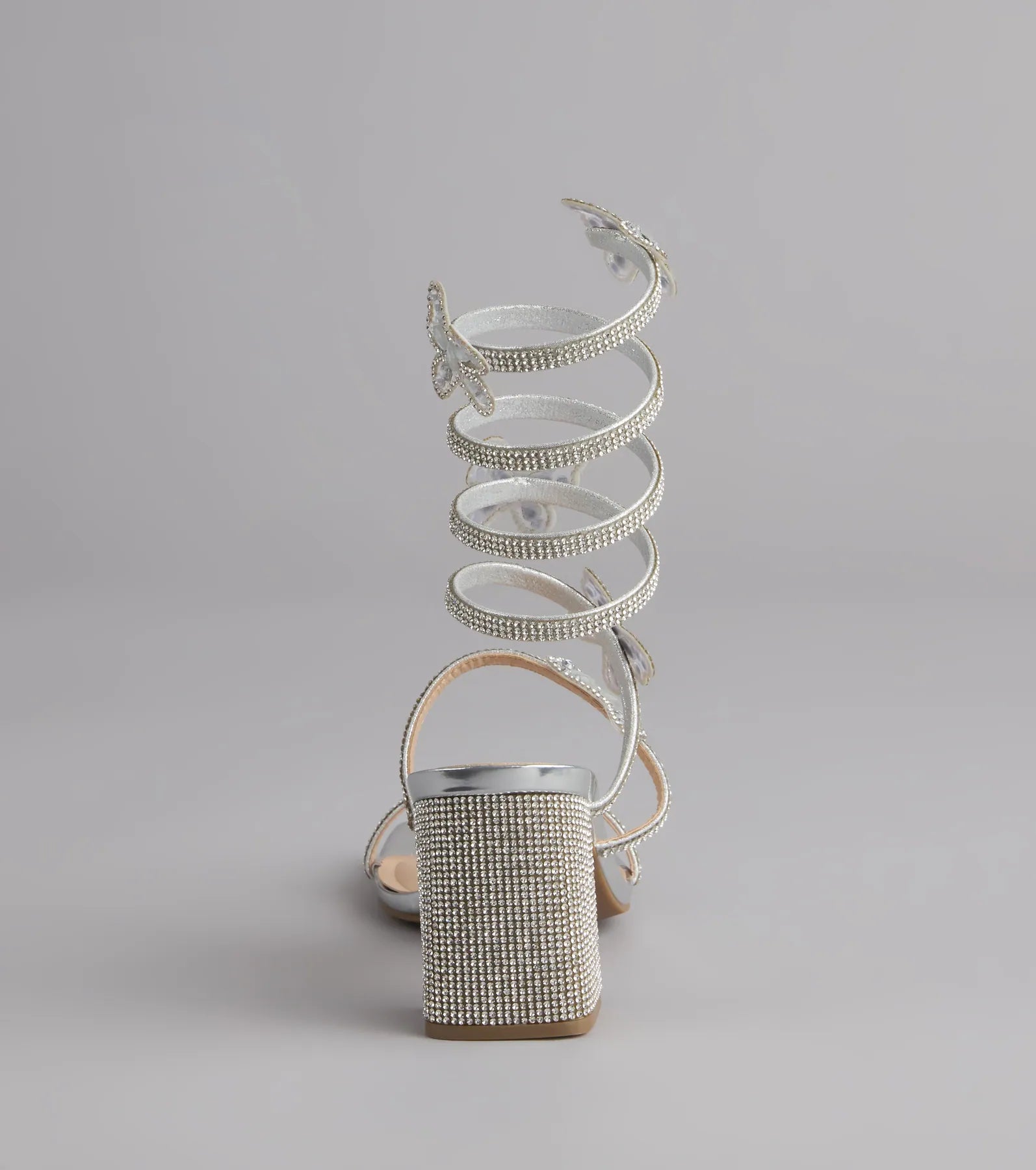 Style made simple with the Flutter Up Rhinestone Spiral Strap Heels in silver, trendy women’s shoes that take your outfit from basic to bold in one step.