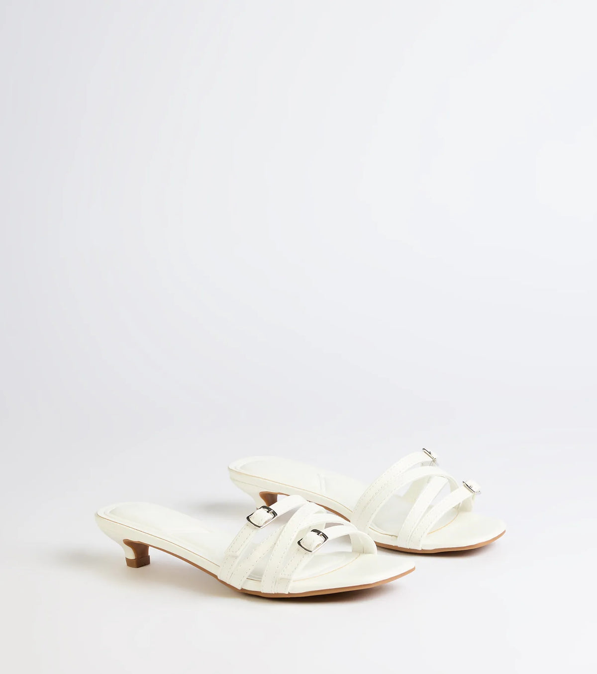 Style made simple with the Trendy Steps Buckle Strap Kitten Heel Mules in white, trendy women’s shoes that take your outfit from basic to bold in one step.