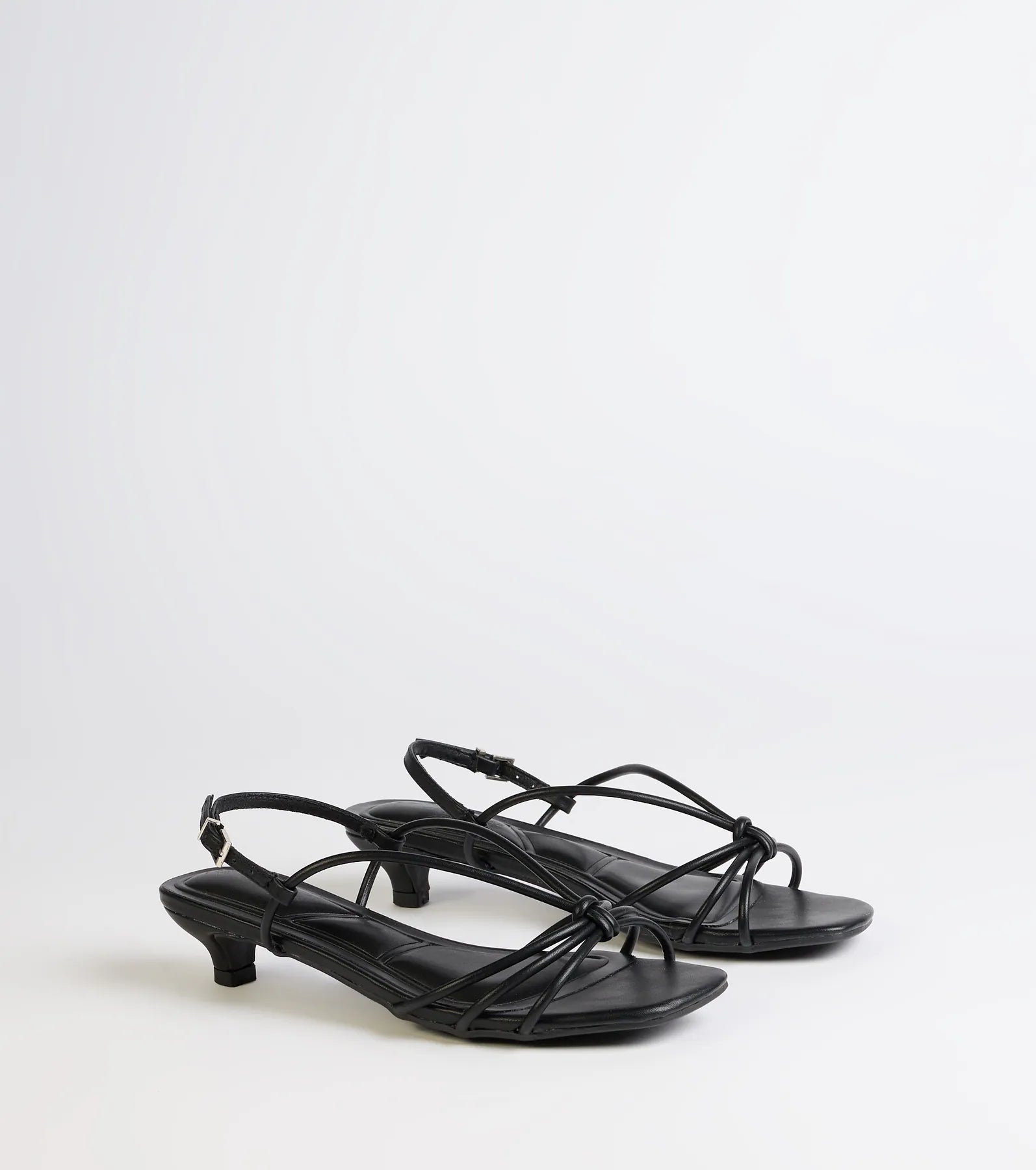 Style made simple with the Tied Together Strappy Kitten Heels in black, trendy women’s shoes that take your outfit from basic to bold in one step.
