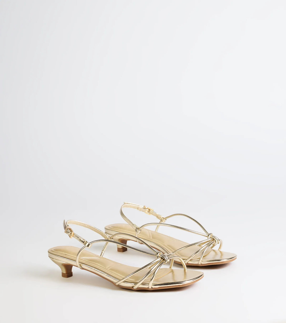 Style made simple with the Tied Together Strappy Kitten Heels in gold, trendy women’s shoes that take your outfit from basic to bold in one step.