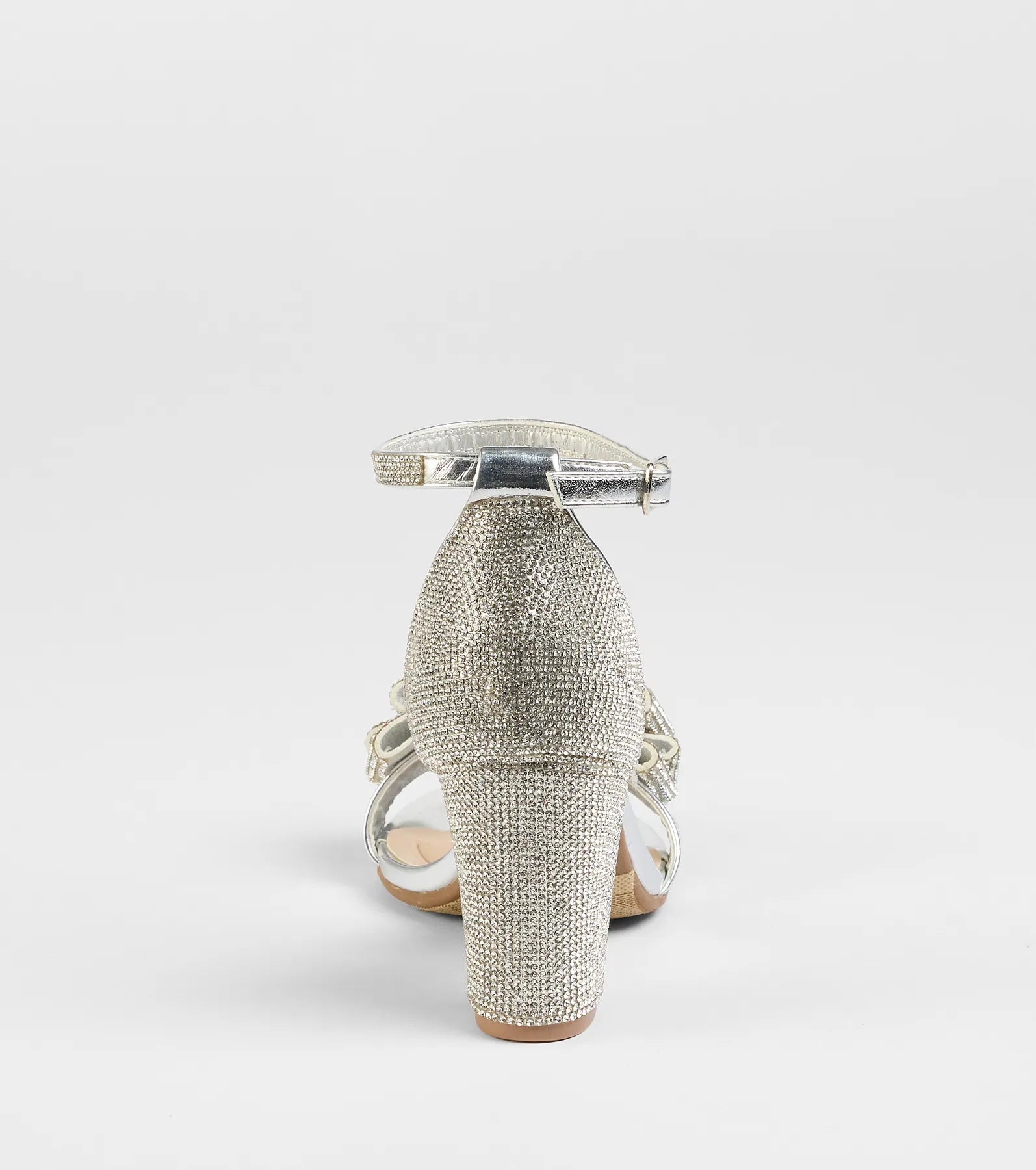 Elevate warm-weather looks with Endless Glam Rhinestone Bow Block Heels in silver, a pair of trendy sandals bringing chic, modern flair to every step.