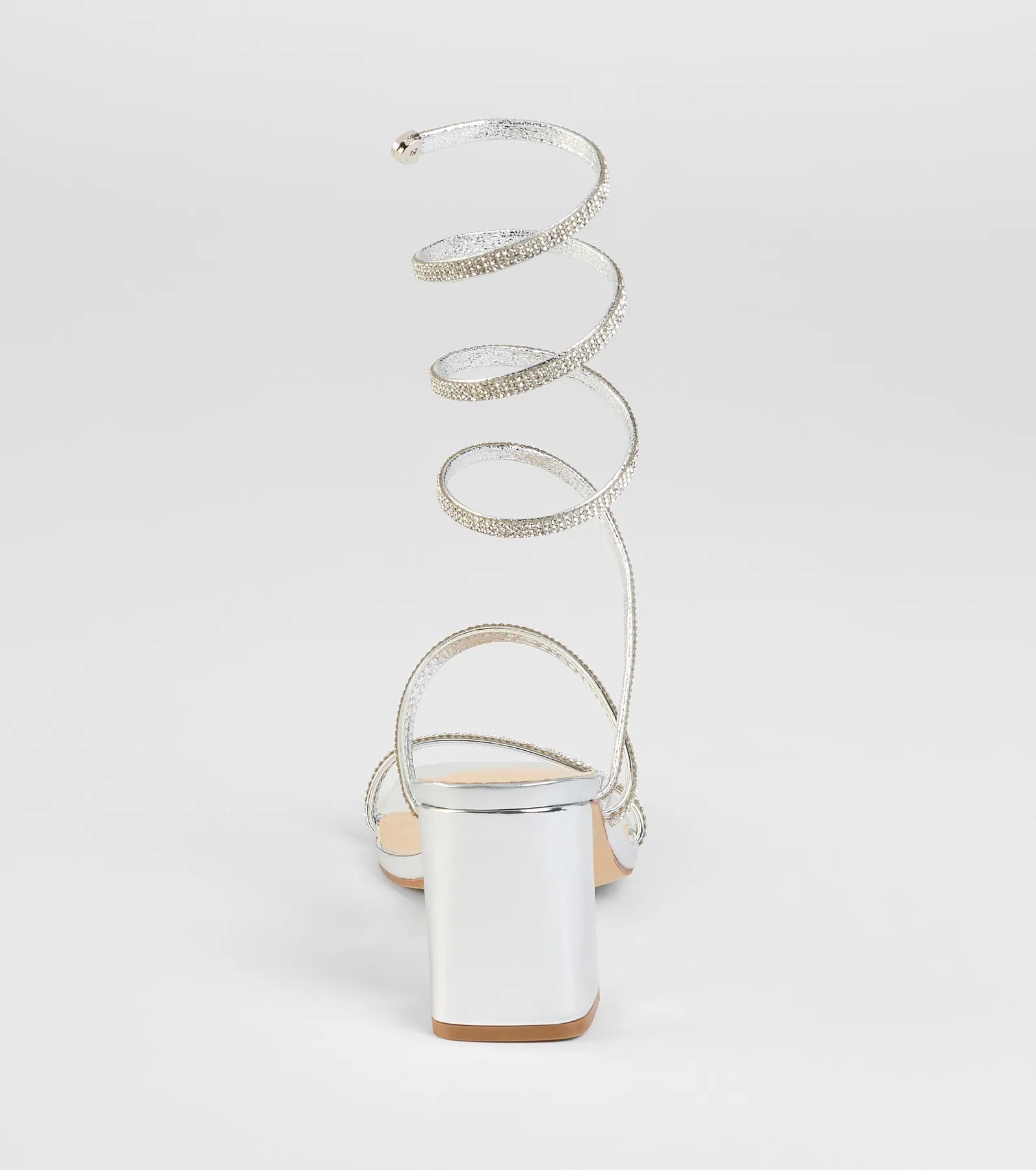 Elevate warm-weather looks with Sparkle And Shine Rhinestone Spiral Block Heels in silver, a pair of trendy sandals bringing chic, modern flair to every step.