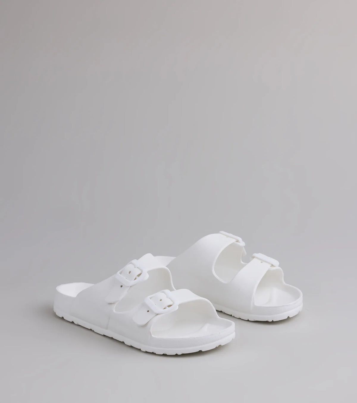 Style made simple with the Tag Along Strappy Buckle Sandals in white, trendy women’s shoes that take your outfit from basic to bold in one step.
