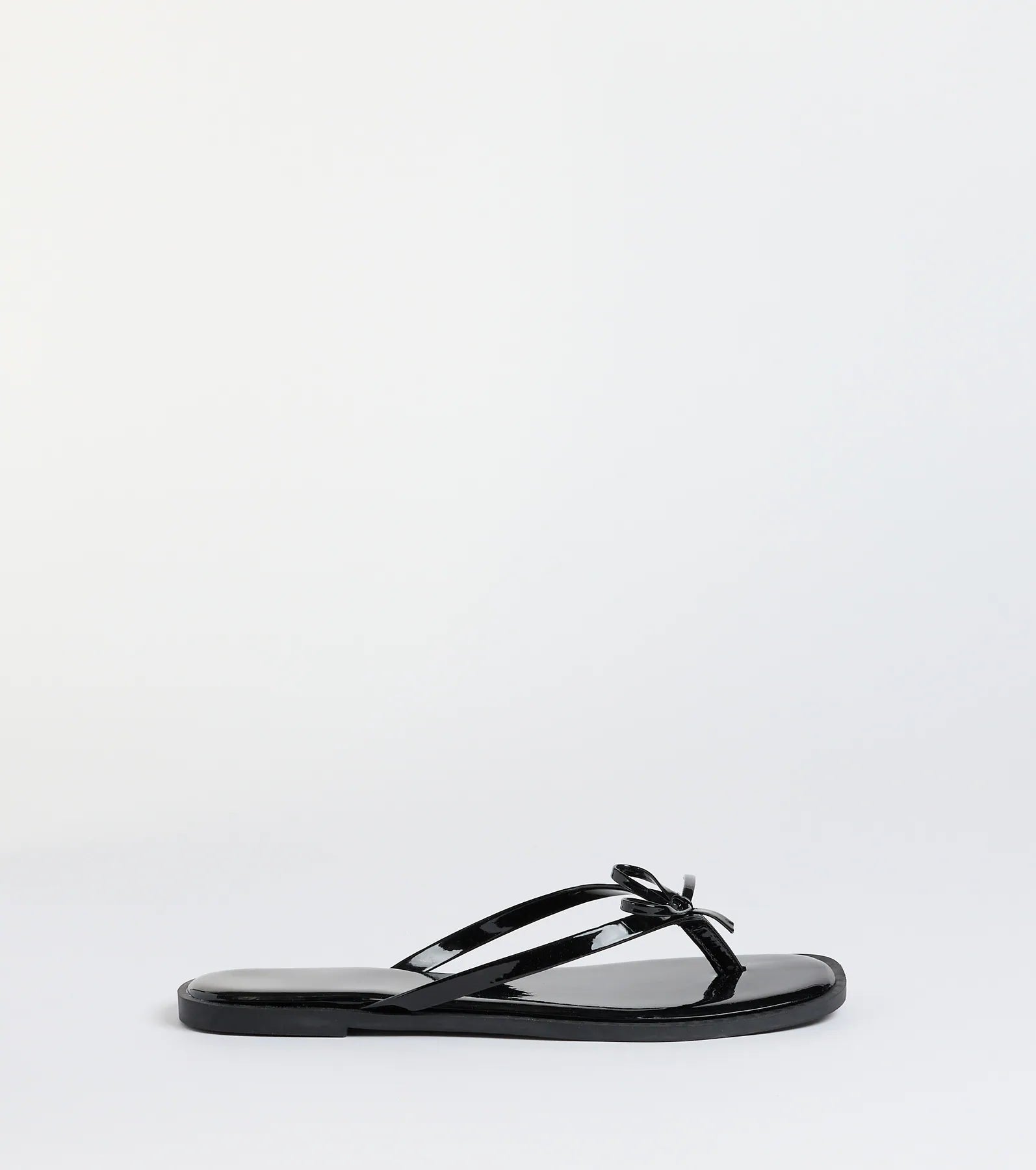 Elevate warm-weather looks with Dainty Looks Bow Thong Sandals in black, a pair of trendy sandals bringing chic, modern flair to every step.