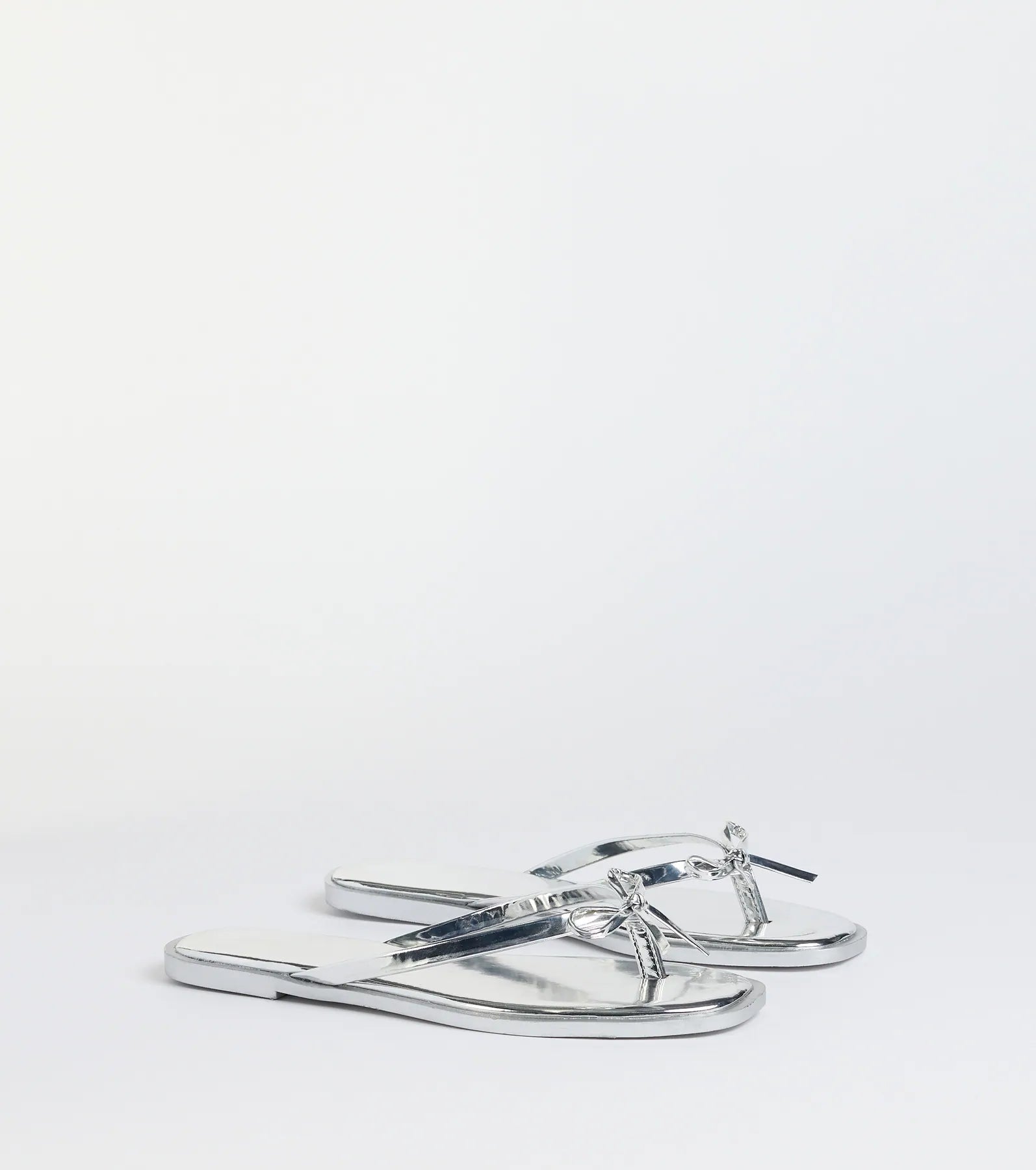 Style made simple with the Dainty Looks Bow Thong Sandals in silver, trendy women’s shoes that take your outfit from basic to bold in one step.