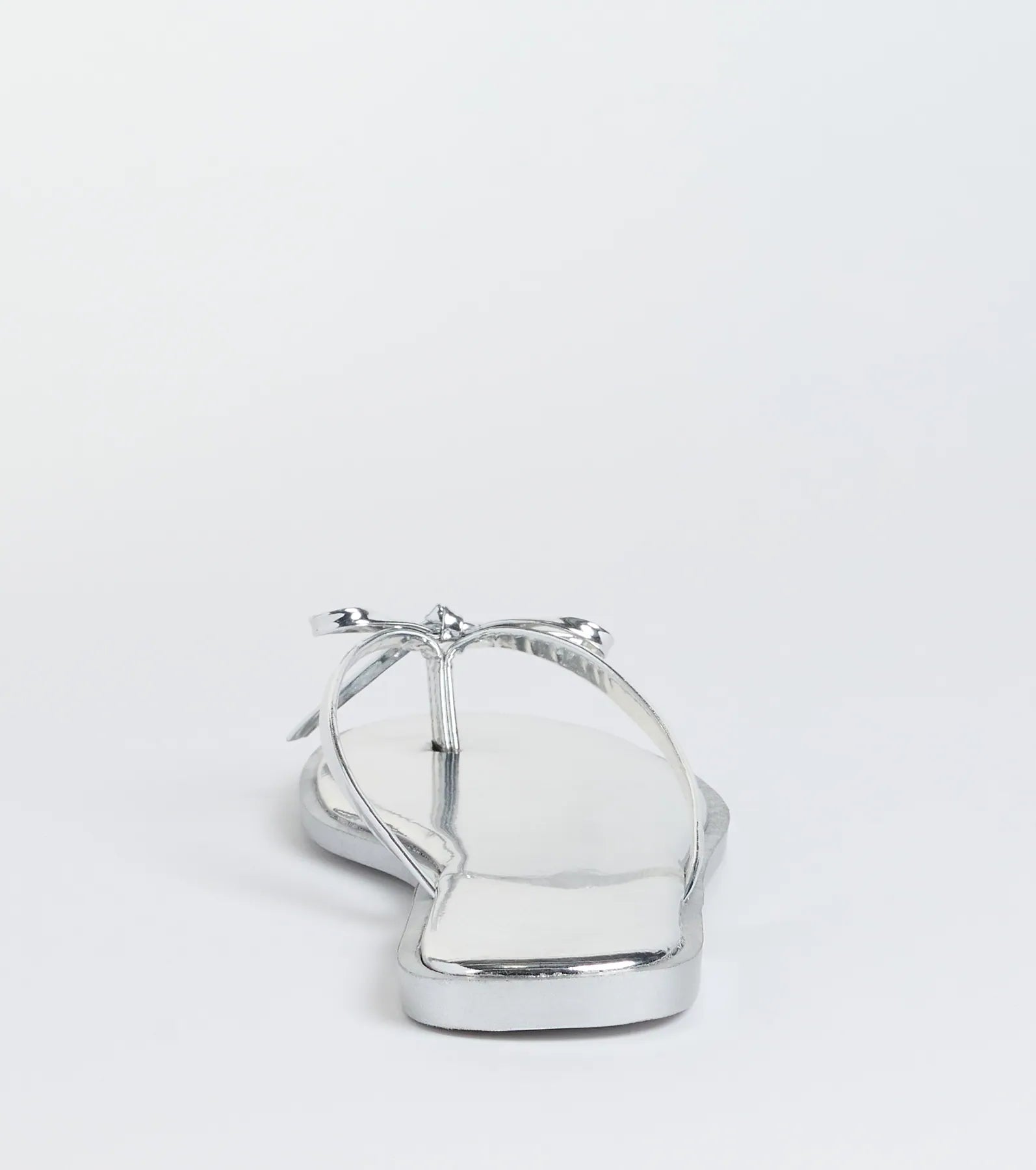 Elevate warm-weather looks with Dainty Looks Bow Thong Sandals in silver, a pair of trendy sandals bringing chic, modern flair to every step.